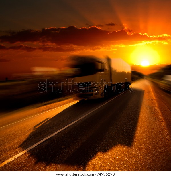 The truck on highway. A\
sunset.