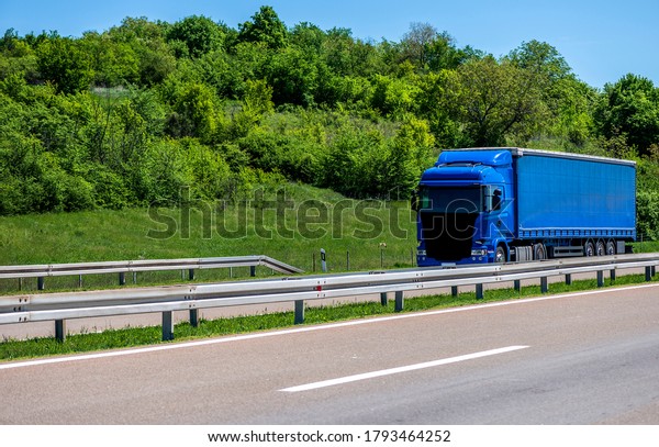 Truck on the highway through countryside. Truck\
driving on the road.