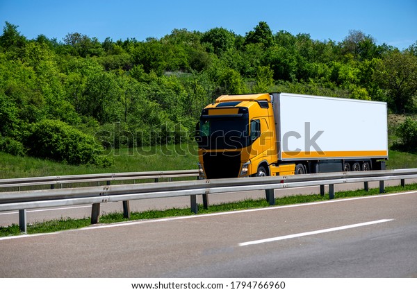 Truck on the highway through countryside. Truck\
driving on the road.