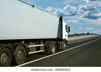 truck is on the road, side view, empty space on a white container - concept of cargo transportation, trucking industry