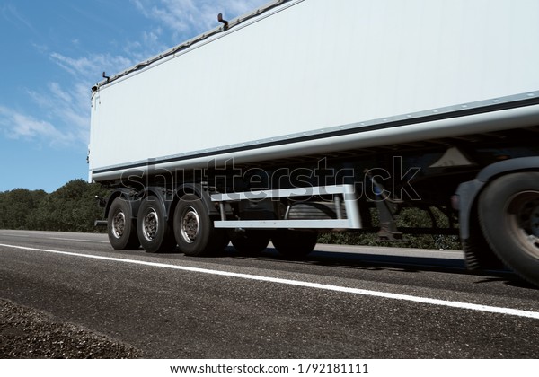 truck on the\
road, side view, empty space on a white container - concept of\
cargo transportation, trucking\
industry
