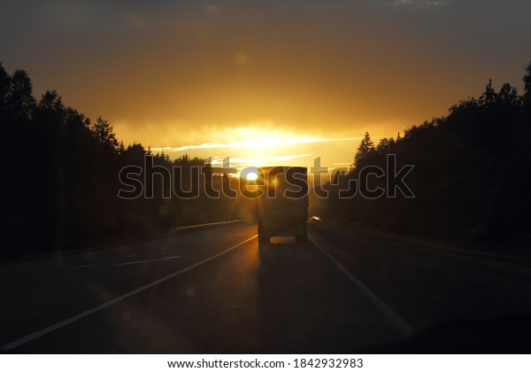 Truck on the road\
at sunset. Track at night
