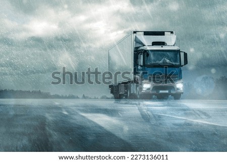 
truck on wet road in heavy rain under cloudy sky