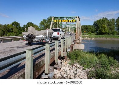 A Truck Pulling Boat On Trailer On River Bridge Meeting A Car