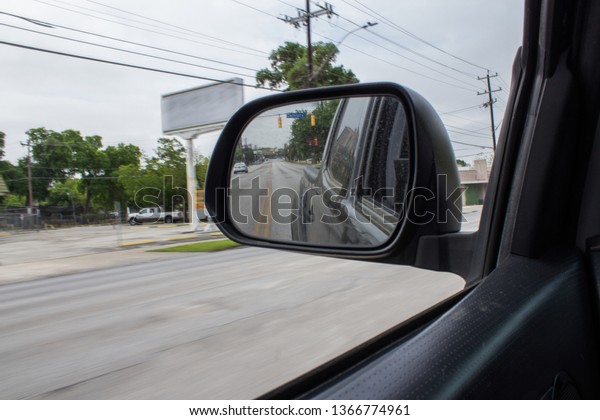 Truck rear view mirror driving down a street in
San Antonio Texas.