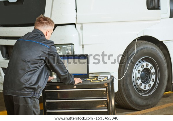 Truck repair service. Mechanic makes computer\
diagnostic of the\
semitruck