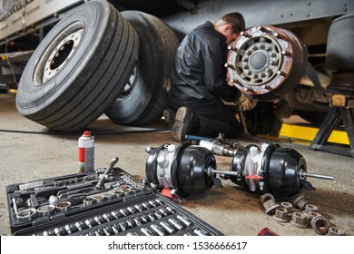 Truck repair service. Mechanic works with brakes in truck workshop