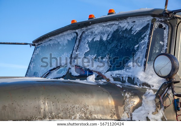 truck\
rides in the snow, car glass covered with\
ice.