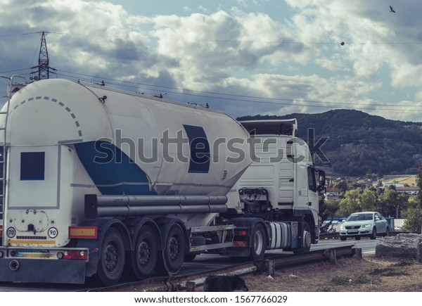 Truck with silo trailer. Without logo.Tanker truck\
carrying diesel.  Truck carrying fuel or oil. Cistern in traffic. \
Rear view with a metal fuel tanker truck. No logo or name. Sibiu,\
October 14, 2019