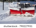 a truck with a snow blade clears snow after a storn  in a residential area in Michigan USA