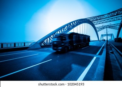 truck speeding through a bridge of ciy,blue toned.