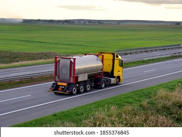 Truck With Tank Container Driving Along Highway. International Bulk Gas And Liquid Transportation Liquefied Gas And Cryogenic Liquid Gas. Transporting Especially Chemical Products And Dangerous Goods.