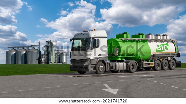 Truck with a tank with the inscription\
BIO on the background of silos. Biofuel\
concept.