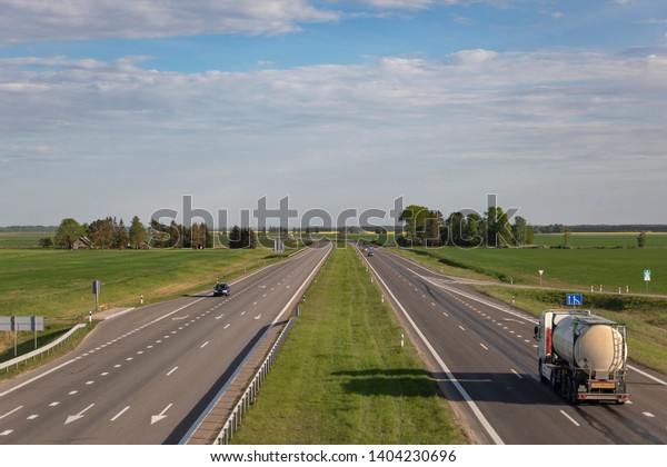 Truck\
with tank on highway at the nice summer day\
evening