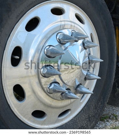 Truck tire sporting a shiny wheel with chrome spiked lug nuts