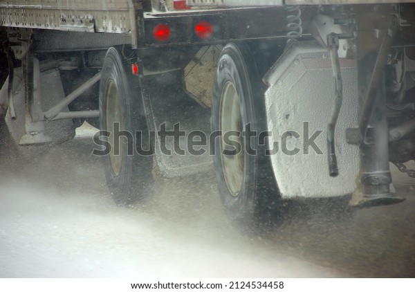 Truck tires spinning on highway during\
snowstorm,   Oregon, Pacific\
Northwest