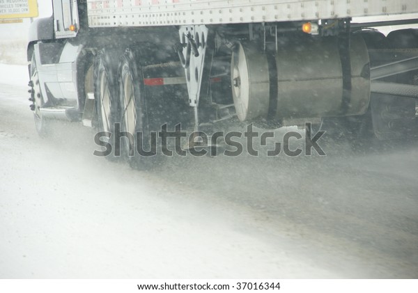 Truck tires spinning on highway during\
snowstorm,   Oregon, Pacific\
Northwest