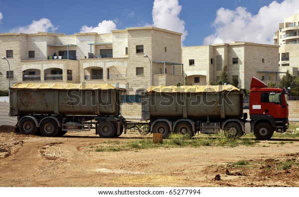 Truck with\
trailer with buildings as a\
background