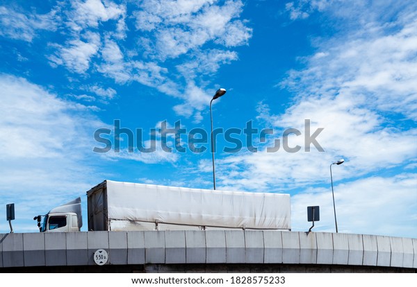 Truck transport logistics. Elevated concrete\
highway road. Truck with containers on the road delivery goods for\
export. Truck freight concept. Freight transport by road. Lorry\
transport cargo.