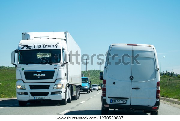 Truck transporting goods in traffic. The truck is\
MAN and belongs to the \