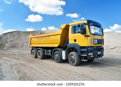 Truck transports sand in a gravel pit - gravel mining in an open pit mine 