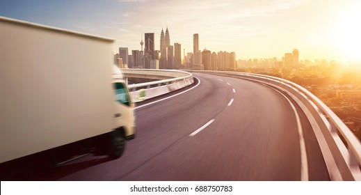 Truck traveling on road at sunrise - speed and delivery concept.