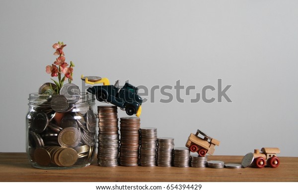 Truck try to put\
coins in  jar of coins  with flower on top, ladder of coins money,\
car load coins money  