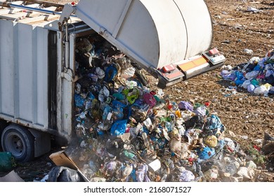 Truck unloading garbage on an open air dump. Waste recycling - Shutterstock ID 2168071527