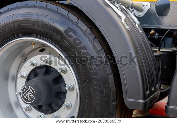 A truck wheel with a new Cordiant tire under a\
plastic fender. Close-up of a new tire on a stamped steel rim.\
Moscow, Russia - May 25, 2021