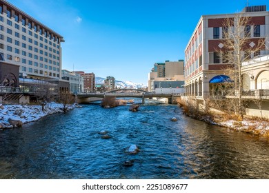 Truckee River flowing through Downtown Reno with hotels, casinos and the Virginia Street bridge in view after a recent snowstorm during winter.