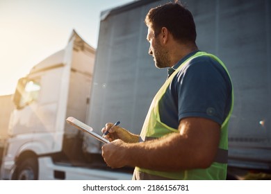 Trucking Company Dispatcher Going Through Checklist On Parking Lot.