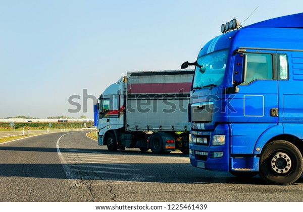 Trucks in the asphalt road of Poland.\
Lorry transport delivering some freight\
cargo.