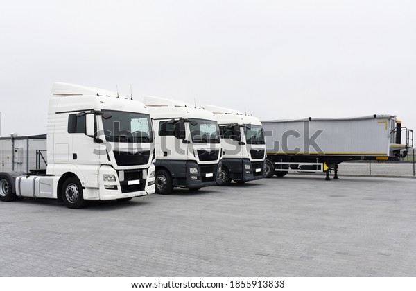Trucks with cargo trailers in\
the parking lot, Freight transport by road, Logistics and\
transport.