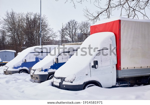 trucks covered with snow after a heavy\
snowfall. winter city\
landscape.