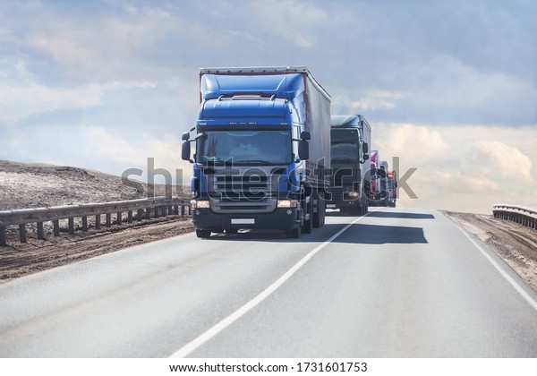 Trucks Deliver Goods on a Country Highway under a\
Cloudy Sky