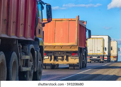 Trucks And Dump Trucks Go On Highway In Sunny Day