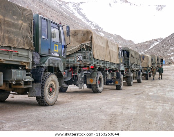 The trucks of
Indian military convoy park on the road near the rock mountain. Leh
Ladakh, India. June 2018.