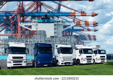 Trucks In The International Seaport Against On A Background Of A Ship Loaded With Containers. International Trade And Logistics Concept