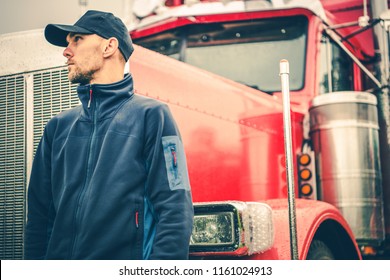 Trucks And Land Transport Industry Theme. Caucasian American Semi Truck Driver In Front Of His Heavy Duty Lorry. 