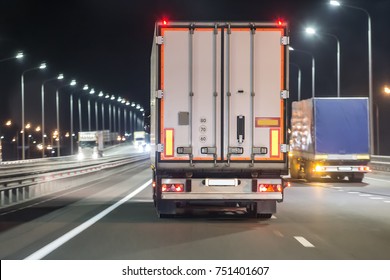 Trucks move on a night illuminated freeway