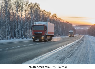 Trucks move in winter along country road along the forest