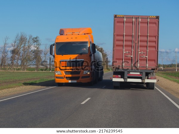 Trucks\
moving in opposite directions on a country\
road