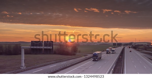 trucks on the highway at\
sunset