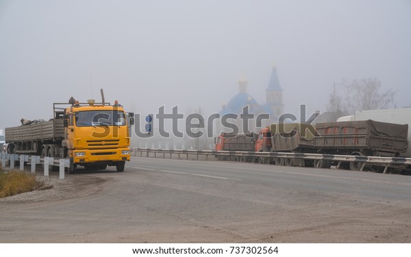 trucks on the road in\
the misty morning