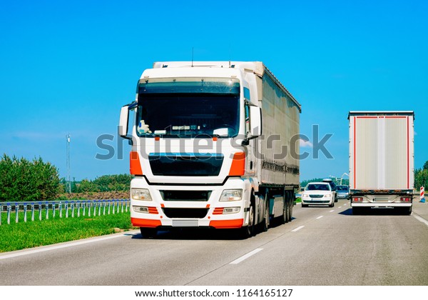Trucks on the road of Poland. Lorry transport\
delivering some freight\
cargo.