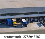 Trucks are parked at loading docks in a logistics center for cargo handling and shipment processing during daylight.