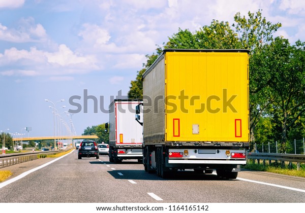 Trucks in the road at Poland. Lorry transport\
delivering some freight\
cargo.