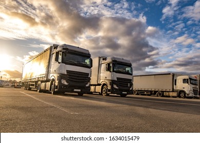 Trucks in a row with containers in the parking lot. Logistic and Transport concept