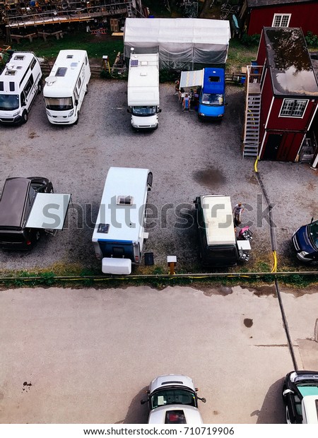 Trucks settlement. Aerial view of camping in\
Stockholm, Sweden. Summer seascape with trucks, sunny day. Top view\
from flying drone