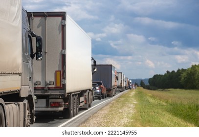 Trucks Are Stuck In Traffic. A Column Of Semi-trailers On The Freeway. Concept Of Disruption In Transportation Logistics And Supply Chains